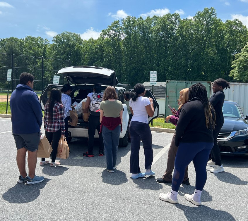 Students packing a car with donated clothes and books